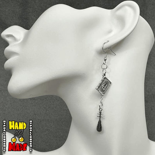 Handmade Game Master Tome Gaming Earrings featuring silver book charm and hanging cudgel charm with silver French hooks.