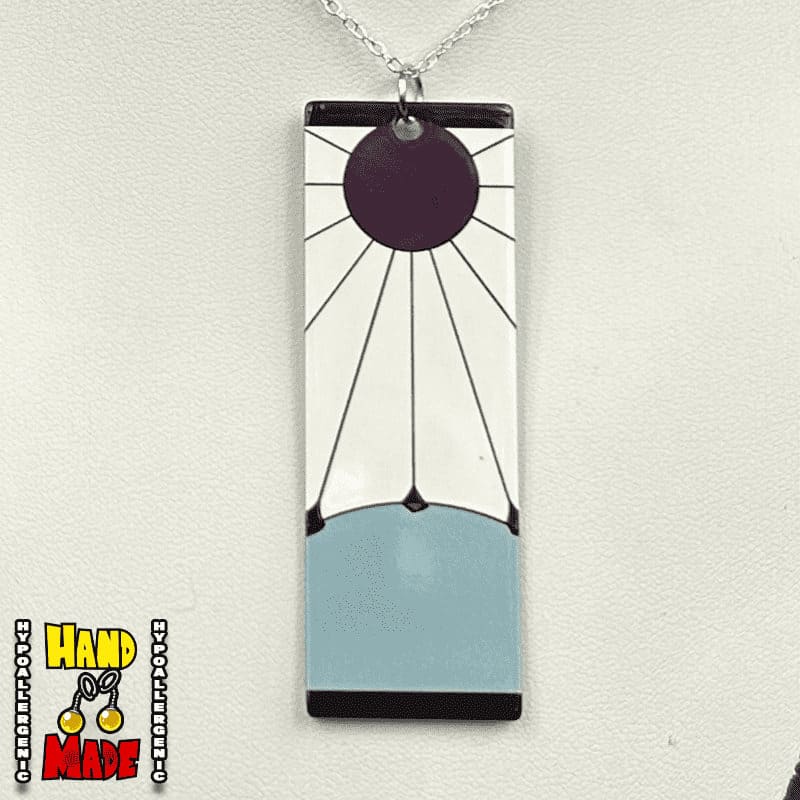 Maroon circular sun with black rays rising over a grey hill with black borders on top and bottom, paired with a sterling silver chain and silver jump ring.
